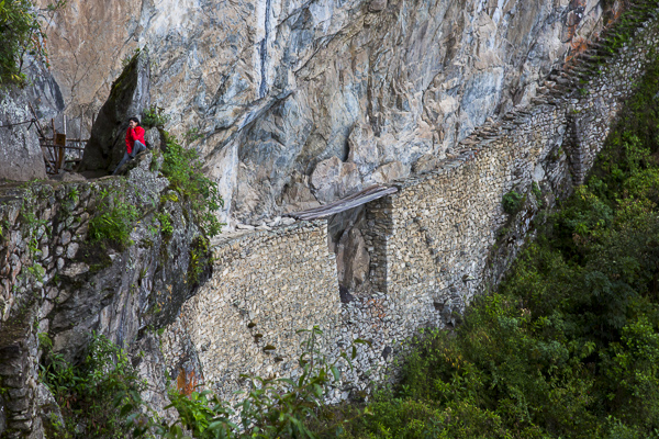 A view of the Inca Bridge which is part of a trail that heads west out of Machu Pichu.  To prevent outsiders from entering Machu Pichu on this trail, a 20-foot gap was left in this section of the carved cliff edge over a sheer drop. Two tree trunks could be used the bridge the gap which was otherwise impassable.