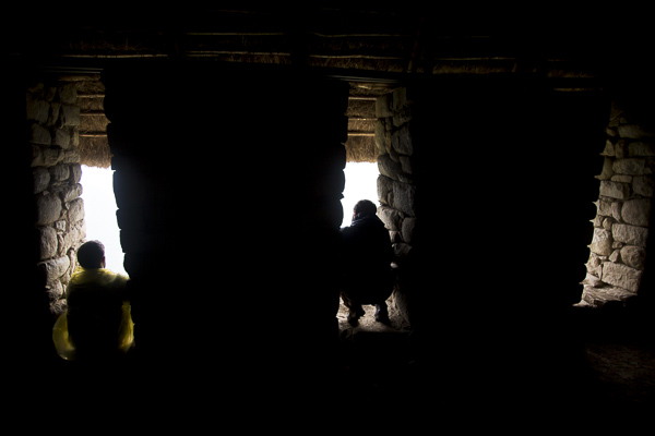 Visitors look ouf of Machu Pichu's trapezoidal windows at the breathtaking view of the Andes. Because Machu Pichu was built between two fault lines, the Incans took great pains to build it to withstand earthquakes. Trapezoidal doors and windows which tilt inward from bottom to top was one of the features used to make the buildings more earthquake-proof. 