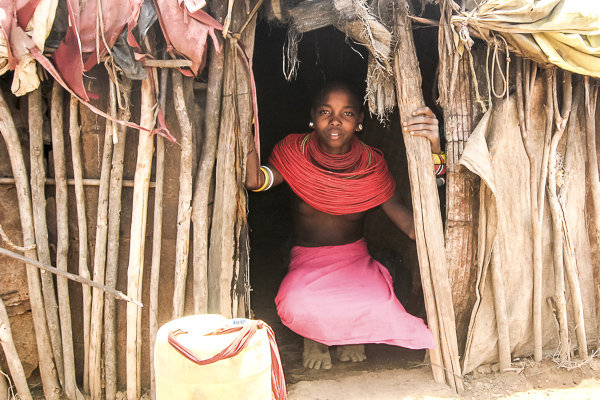 A portrait taken at the entrance of her "boma"--a traditional Samburu home made out of mud, hides and grass mats strung over pole-- by Generica Lesuper.